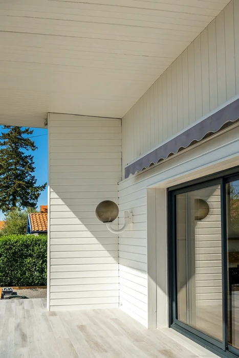 Terrasse couverte moderne avec bardage bois peint en blanc, plafond à lames horizontales