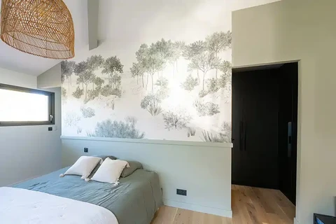 Chambre contemporaine avec tête de lit intégrée, papier peint panoramique motif forêt en camaïeu de verts