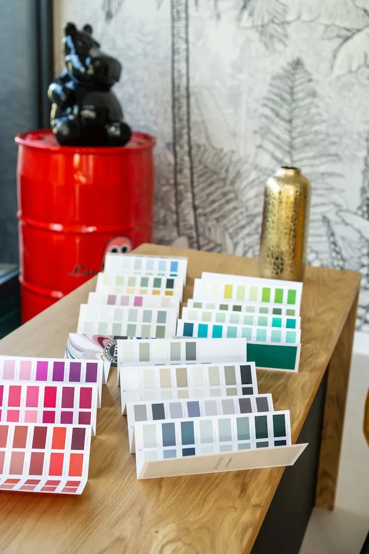 Espace de travail intérieur avec nuancier de couleurs d'imprimerie étalé sur table