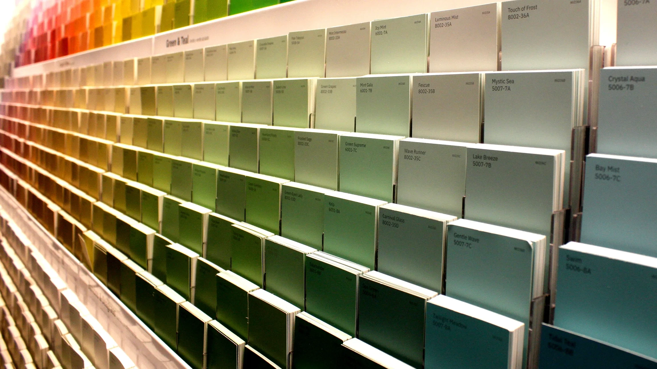 Scène d'atelier graphique avec pinceau à manche doré et soies noires posé sur nuancier couleurs imprimé