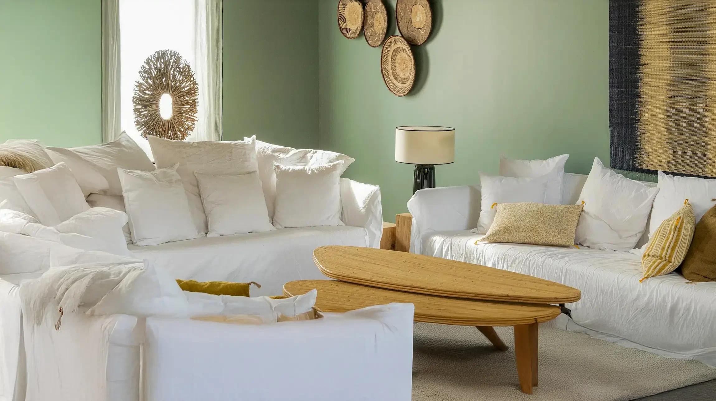 Main tenant un pinceau appliquant de la peinture rouge sur un mur intérieur