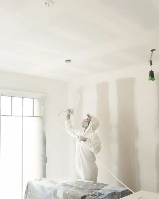 Peintre de maison peignant l'intérieur d'une maison meublée