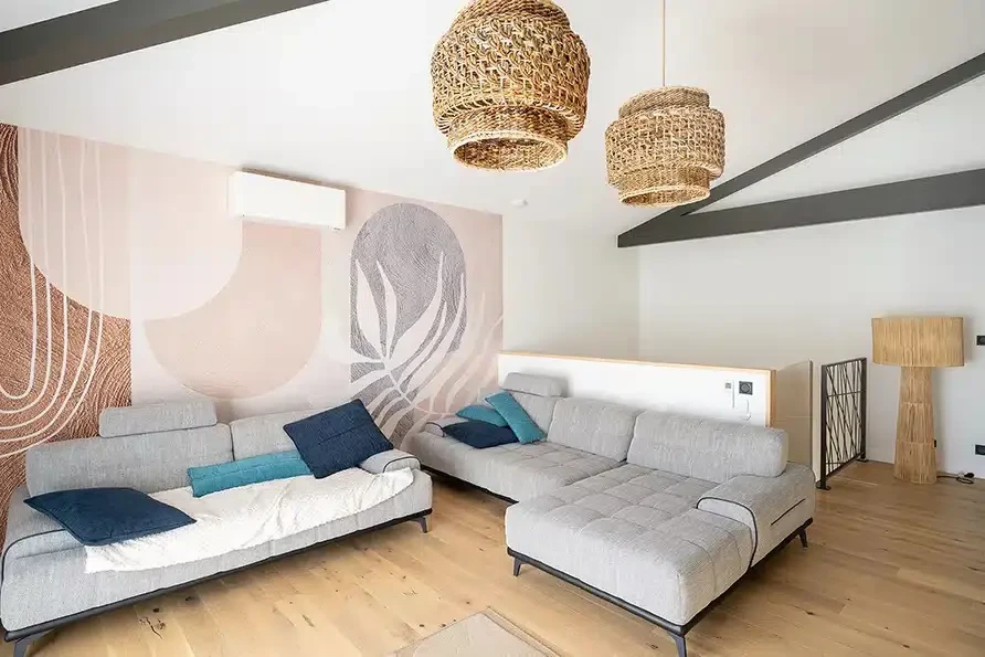 Personne tenant un nuancier de couleurs en éventail contre un mur blanc, évaluant des teintes pour travaux de peinture intérieure