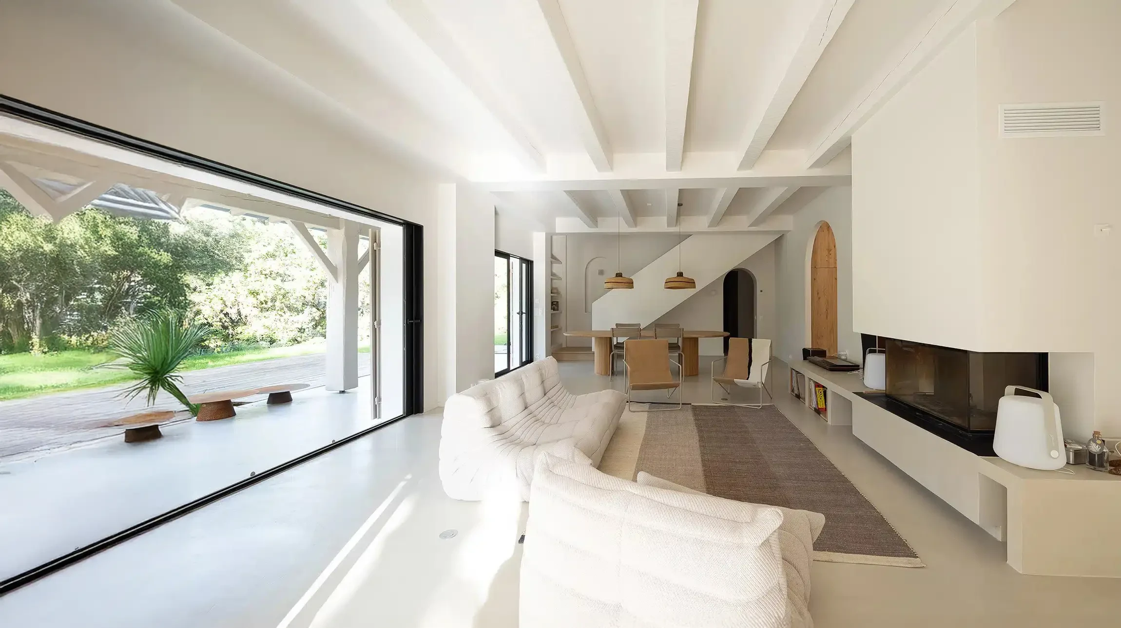 Peintre professionnel en tenue de travail blanche et polo bleu applique de la peinture blanche sur un mur int&eacute;rieur &agrave; l'aide d'un rouleau &agrave; peinture